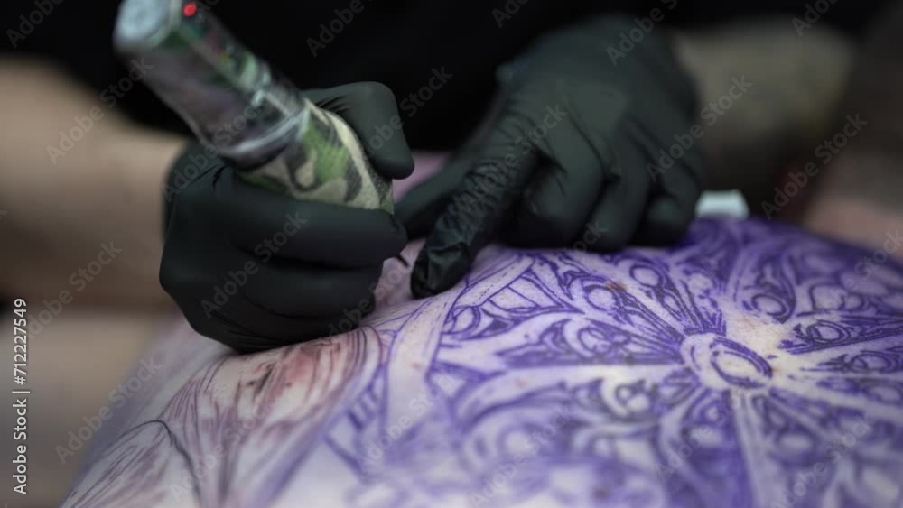 Plano detalle de tatuador realizando tatuaje