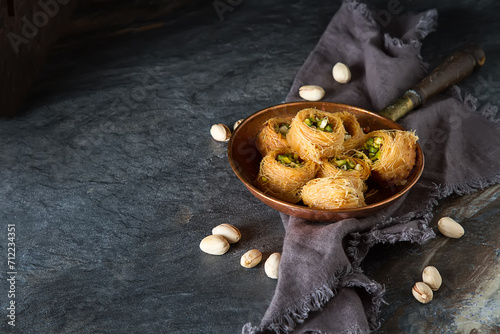 Traditional arabic dessert baklava with pistachios. Dark background