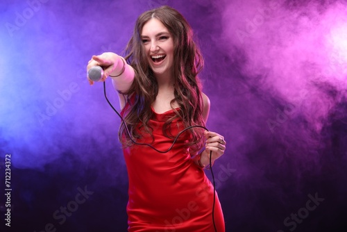 Emotional singer giving microphone to others in color lights