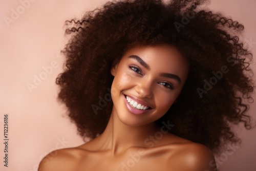 african american girl beauty portrait, clean healthy skin on beige background. Smiling beautiful woman. Curly hair