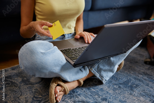 Young woman booking travel tour or ticket online using laptop and credit card