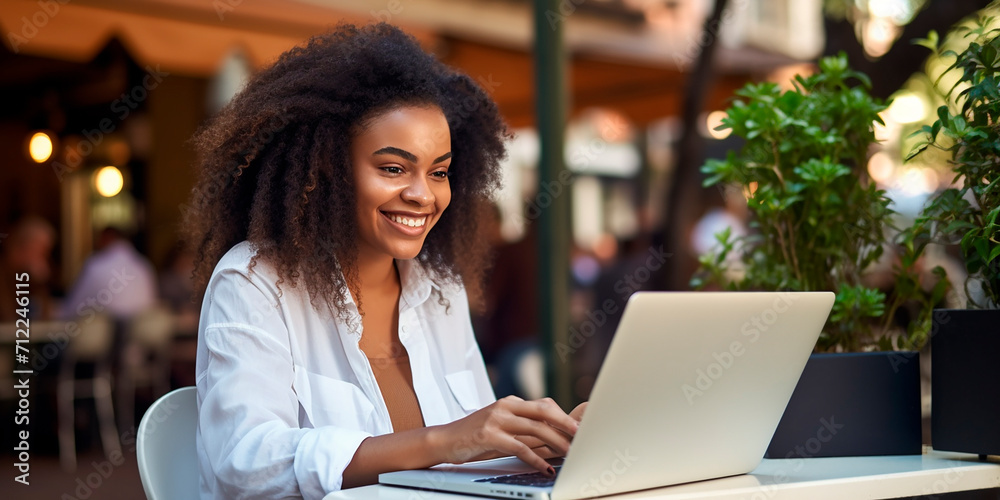 young beautiful dark-skinned girl working on a laptop in a cafe - obrazy, fototapety, plakaty 