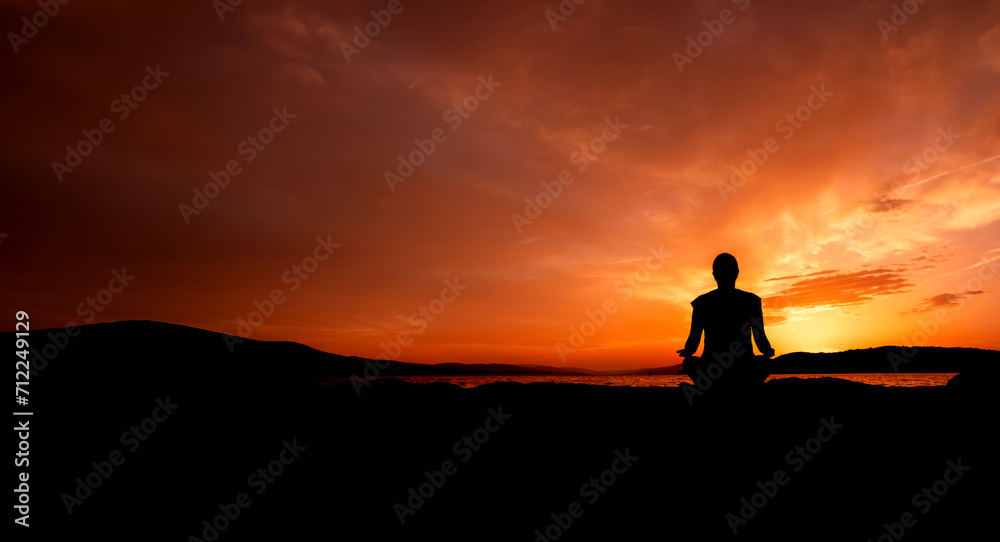 sylwetka kobiety medytującej na plaży przy zachodzie słońca	 - obrazy, fototapety, plakaty 