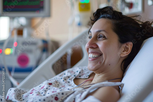 A female patient lying in a hospital bed smiling