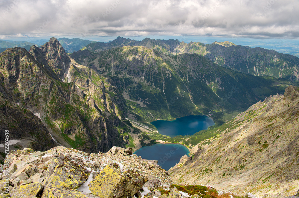 View from the mountain Rysy of Morskie Oko, Czarny Staw lakes. High Tatras. Border of Poland and Slovakia. Hiking and climbing Slovakia. Landscape of mountain tops and the lake between them.