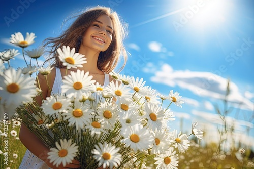 girl in a field of daisies. Smiling girl with white flowers on a blue sky background