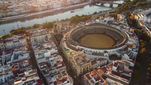 Seville, Spain: Aerial drone footage of the Seville historic city center with the Plaza de Toros, the bullfighting area close to the  Guadalquivir river in Andalusia largest city at sunset.  photo