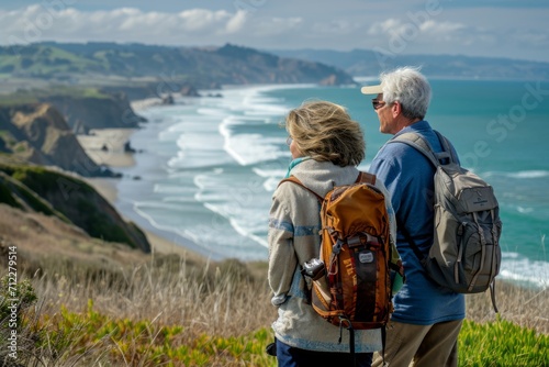 Senior couple admiring the scenic Pacific Ocean coast while hiking, filled with wonder at the beauty of nature during their active retirement