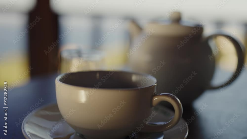 Closeup on ceramic cup near teapot with fresh tea brewing on cafe table. Preparing traditional chinese tea for drinking Closeup on ceramic cup near teapot with fresh tea brewing on cafe table. Preparing traditional chinese tea for drinking