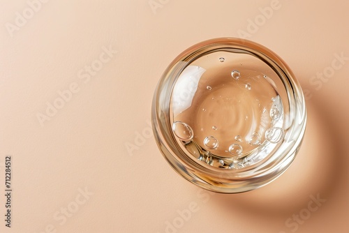 Transparent cosmetic gel viewed from top on a beige background