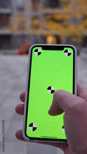 Unrecognizable person swiping using smartphone mockup screen outside on blurred background