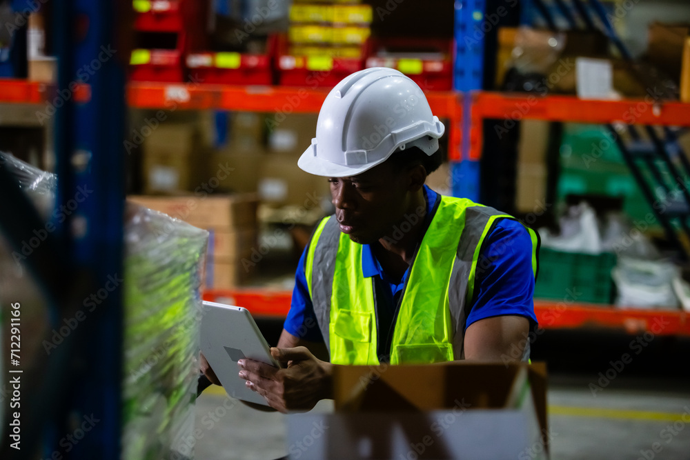Male american african factory company employee scanning box checking number of products on goods shelves with tablet in warehouse. Man working in logistics and distribution. Import-export warehouse. Male american african factory company employee scanning box checking number of products on goods shelves with tablet in warehouse. Man working in logistics and distribution. Import-export warehouse.