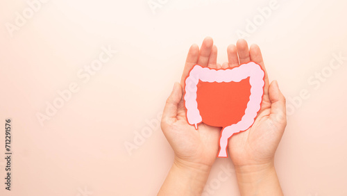 Konstfotografi Hand holding large intestine organ made form paper on beige background
