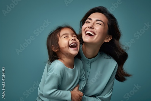 Playful laughing mother and daughter of Asian ethnicity hugging together