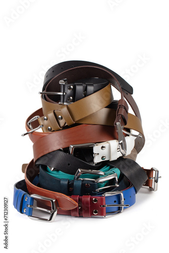 View of various colorful leather belts stacked in a pile. Isolated on white background
