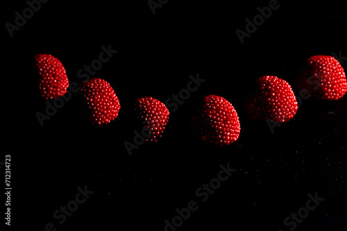 Jujubas de cor preta e vermelha em fundo preto. photo