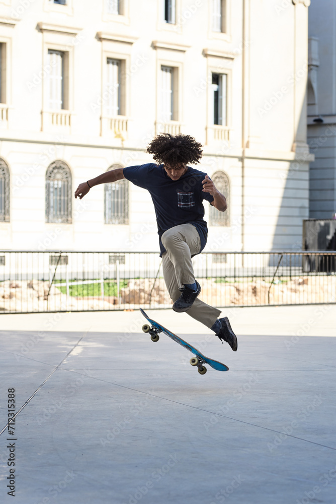 Fototapeta premium Hipster boy performing skating trick in the street.