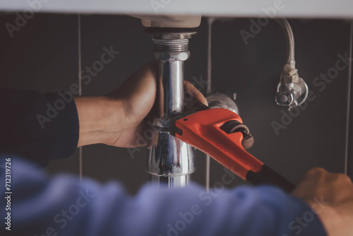 plumber at work in a bathroom, plumbing repair service , fix water plumbing leaks, replace the kitchen sink drain