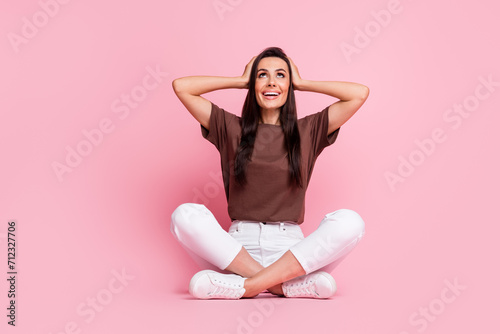 Full body length photo of amazed girlfriend price falling hands touch head amazed looking above smiling isolated over pink color background