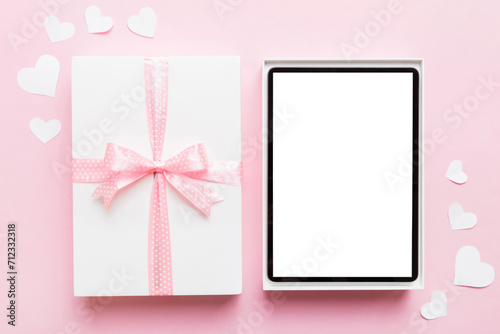 Gift box of open tablet for the holidays with a bow top view