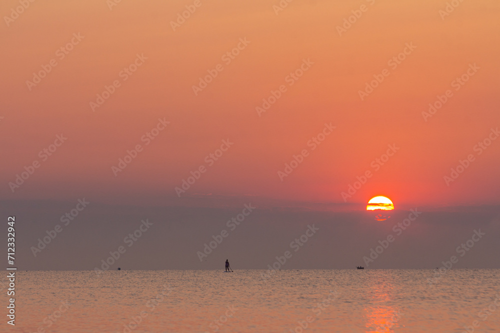 A beautiful dawn over the Black Sea in Odessa. Silhouette of a person riding on a SAP. Ukraine A beautiful dawn over the Black Sea in Odessa. Silhouette of a person riding on a SAP. Ukraine