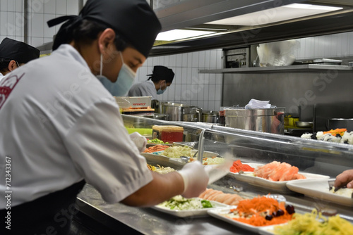 Cozinha de um restaurante de comida japonesa com os cozinheiros trabalhando