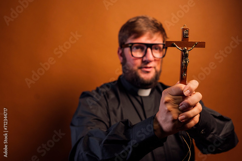 Portrait of an exorcist priest with crucifix and black shirt. photo