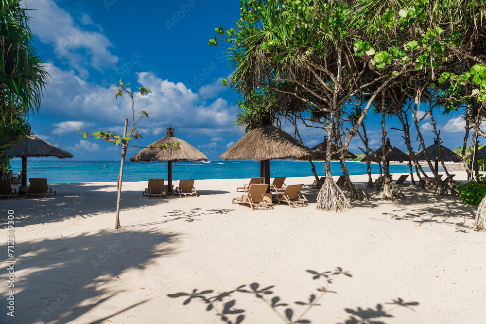 Chairs and umbrellas at private beach with ocean. Holiday tropical banner