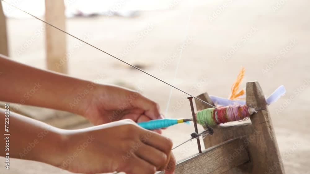 sian woman's hand holding a spool of cotton yarn, rural culture life in Thailand