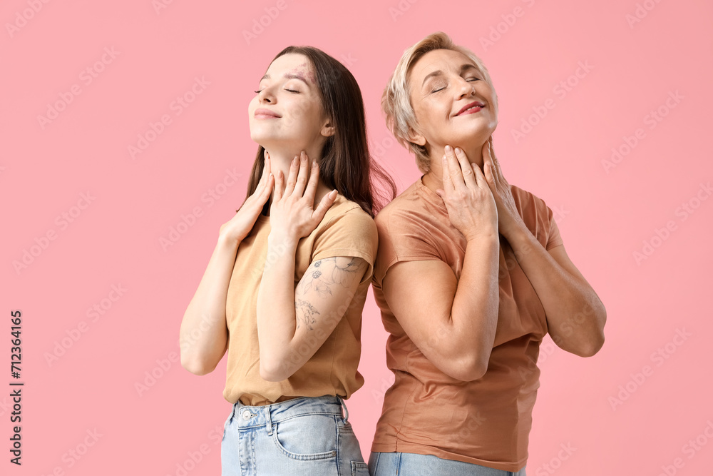 Beautiful women doing face building exercise on pink background Beautiful women doing face building exercise on pink background