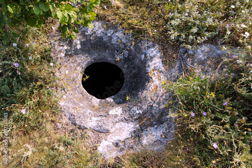 The ancient cave city of Bakla, outside view. Round grain pits for grain storage.