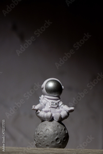 Plastic toy figure astronaut on moon concrete background Copy space. Concept of out of earth travel, private spaceman commercial flights. Space missions and Sustainability © anna.stasiia