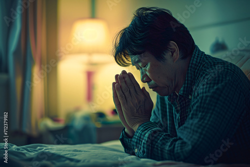 A man praying at his bedside, prayer, faith, belief in god concept photo