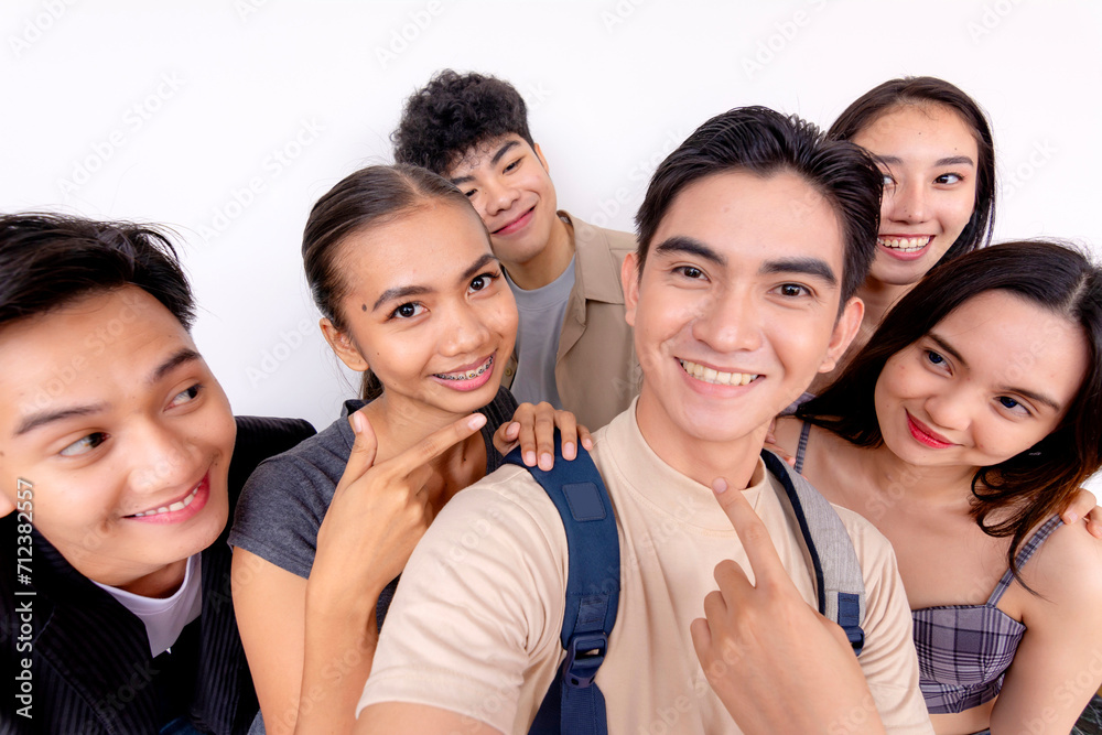 A cheerful group of six young friends smiling and posing for a selfie, capturing a joyous moment together on a plain background. A cheerful group of six young friends smiling and posing for a selfie, capturing a joyous moment together on a plain background.