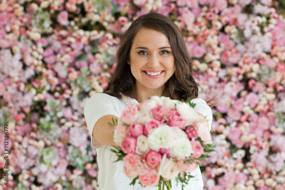 Cheerful lady with flowers. Happy brunette woman indoor portrait Cheerful lady with flowers. Happy brunette woman indoor portrait