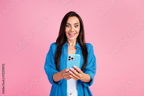 Photo of funny crazy girl with straight hairdo dressed blue shirt straing at smartphone read email isolated on pink color background photo