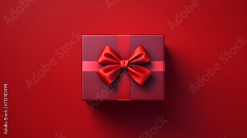 Box, gift and present with bow on red background for surprise prize giving, celebration or party event. Bow, ribbon, wrapping paper and package for Christmas, birthday or special day giveaway. © ReneBot/Peopleimages - AI