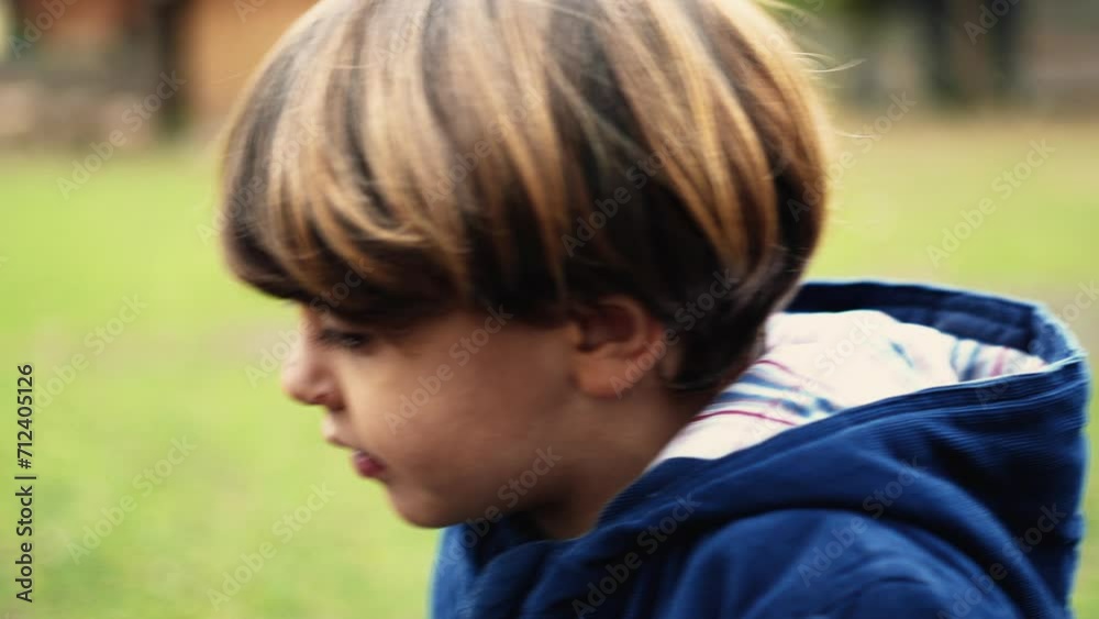 Introspective kid walks forward during fall season, pensive thoughtful 4 year old child daydreaming while walking Introspective kid walks forward during fall season, pensive thoughtful 4 year old child daydreaming while walking