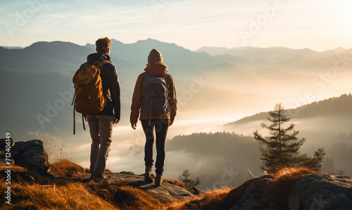 Couple hiker traveling, walking in autumn mountains under sunset
