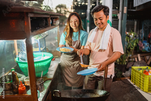 indonesian female helping male seller cooking fried rice