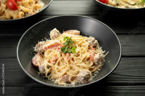 Italian spaghetti pasta with meatballs and parmesan cheese on a plate, table setting in a restaurant