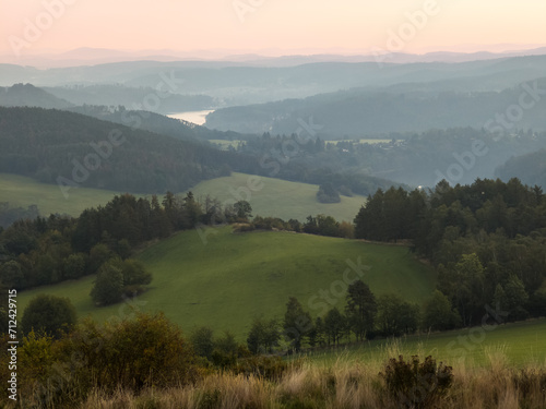 Wooded hilly landscape in the Czech Republic with Milada lookout tower above the Vltava River meander.