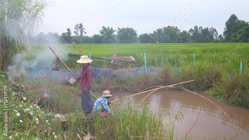 Mother and children family catch fish by square dipnet for fishing photo