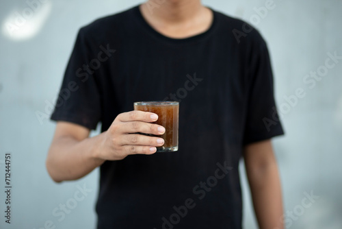 Closeup of a man hands holding a transparent coffee cup at home