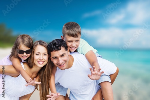 Happy young family with children at the beach.