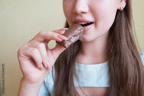 young beautiful girl eating chocolate, close-up