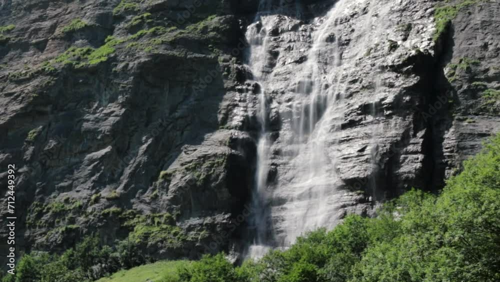 Waterfall cascading down a cliff in summer Waterfall cascading down a cliff in summer