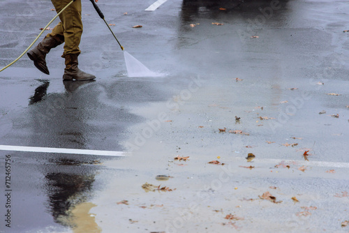 Street is sprayed clean with pressurized water during wet washing process photo