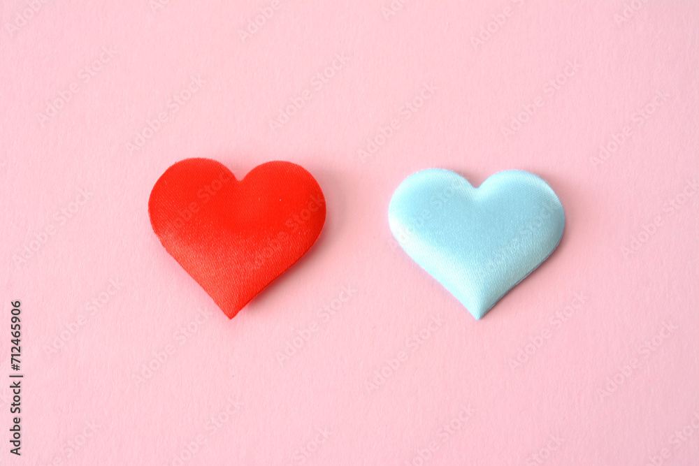 red and blue hearts isolated on the pink background close up