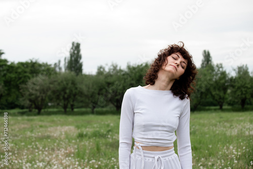 Sportswoman closed her eyes to focus on breathing fresh air. Woman doing meditation technique for relax mind. Female yoga instructor showing pranayama practice on park background